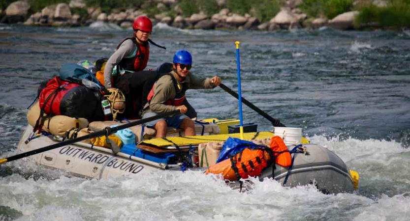 two people navigate whitewater in a raft 
